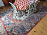une table et des chaises dans une pièce avec un tapis au sol