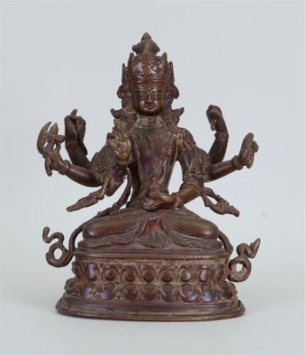 une statue en bronze représentant une femme assise sur une table
