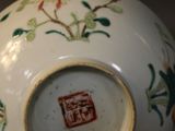 a white vase with a red and green design on it
