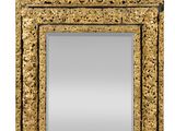 an ornately carved mirror with a gold frame on a white background