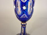 a blue glass with gold and white designs on it