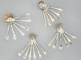 four pieces of silverware with spoons and forks on a table