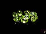 a close up of a bunch of green gems on a black surface