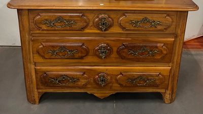 une commode en bois surmontée d'un miroir