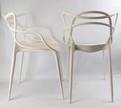 deux chaises blanches placées l'une à côté de l'autre sur une surface blanche