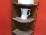 a corner shelf with a pitcher on top of it