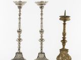 a pair of silver candlesticks and a candle holder