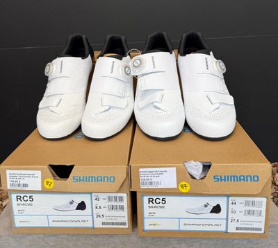 trois paires de chaussures blanches posées sur une boîte en carton