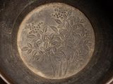 a close up of a metal bowl with a design on it