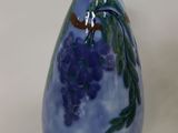 a blue vase with a bunch of grapes painted on it