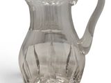 clear glass pitcher on a white surface with a white background