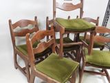 six chairs and a table with green cushions in a room