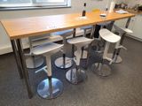 plusieurs tabourets et une table dans une pièce dotée d'une fenêtre
