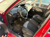 the interior of a red car with a steering wheel and dashboard
