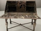 an antique silver desk with a wooden top and roped legs