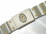 a silver bracelet with gold studs on a white surface