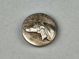 une pièce d'argent sur laquelle est représentée une tête de chien
