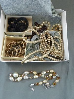 une boîte remplie de perles et d'autres bijoux posée sur une table