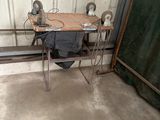une petite table sur laquelle est posé un ordinateur portable, dans un garage