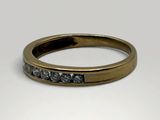 a close up of a gold wedding ring with black diamonds