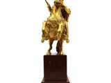 statue of a man on a horse with a sword on a wooden base