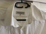 a white shirt hanging on a hanger in a room