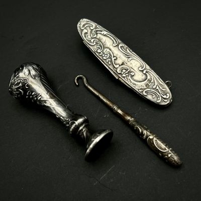 une cuillère en argent et un couteau posés sur une surface noire