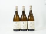 trois bouteilles de vin posées sur une table blanche