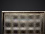 a close up of a metal grill grate on a black background