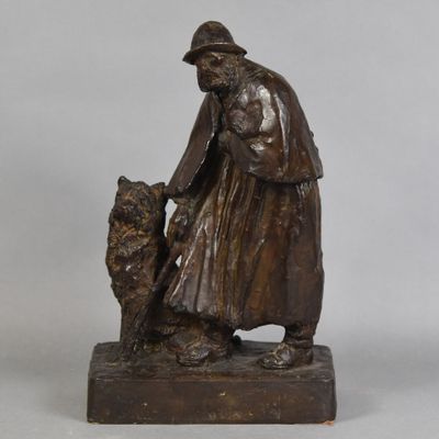 statue en bronze représentant un homme avec un chien, posée sur un socle en bois