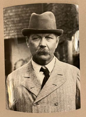une photo en noir et blanc d'un homme en costume et chapeau