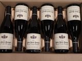 six bouteilles de vin dans un carton sur une table