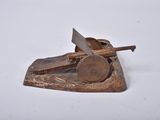 un petit objet métallique posé sur une surface blanche