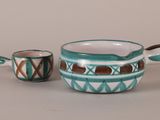 two pieces of pottery sitting on top of a table next to each other