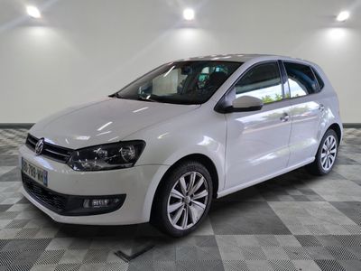 the white volkswagen polo is parked on a checkered tile floor
