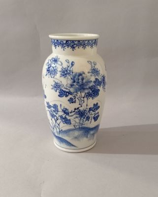 un vase bleu et blanc posé sur une table