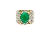 a close up of a ring with a green stone in it