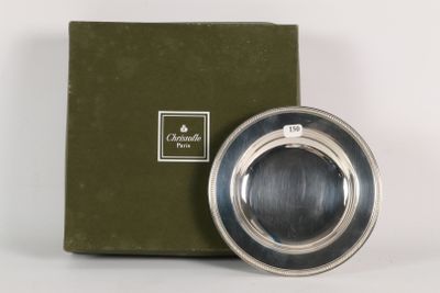 a silver plate that is sitting in front of a green box