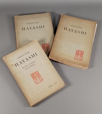 Trois livres sont posés sur une table devant un fond gris.