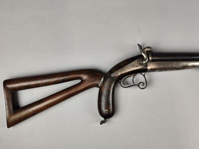 un vieux fusil avec une poignée en bois sur fond blanc