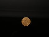 a gold coin sitting on top of a black surface