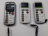 three cell phones sitting next to each other on a table
