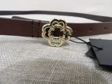 brown leather belt with a gold flower buckle and a black tag