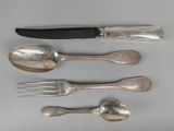 four spoons, a knife, and a fork on a table