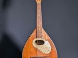 an old wooden mandolin sitting on top of a black surface