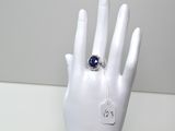 une main de mannequin blanche ornée d'une bague bleue