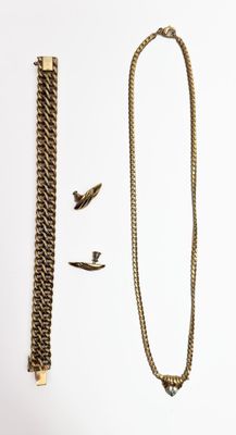 un collier et une chaîne posés sur une surface blanche