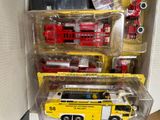 three toy fire trucks and a fire truck in a box