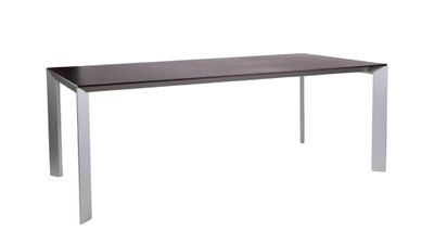 une table avec un plateau en verre et des pieds en métal, sur fond blanc