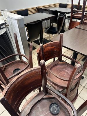 Dans un restaurant, les tables et les chaises sont alignées, prêtes à accueillir les clients.